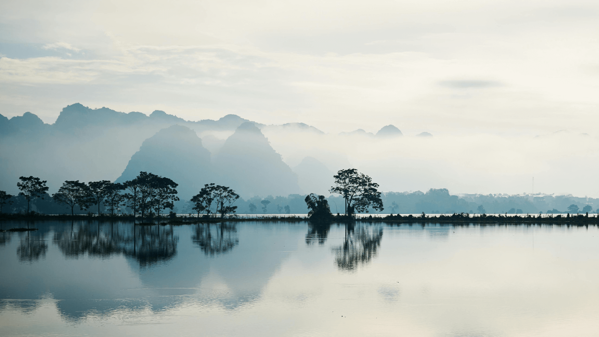 Misty lake with distant mountains and calm reflections, illustrating what is an empath through emotional depth and perspective.